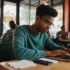 A college student working on a laptop at a café, symbolizing freelancing opportunities.